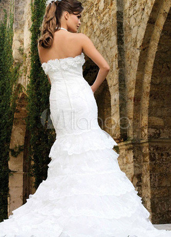 white wedding dress with ruffles and satin band